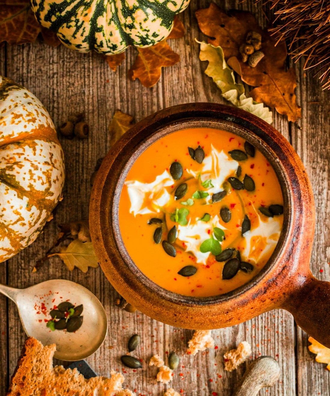 Caldo de abóbora em panela de barro com sementes tostadas